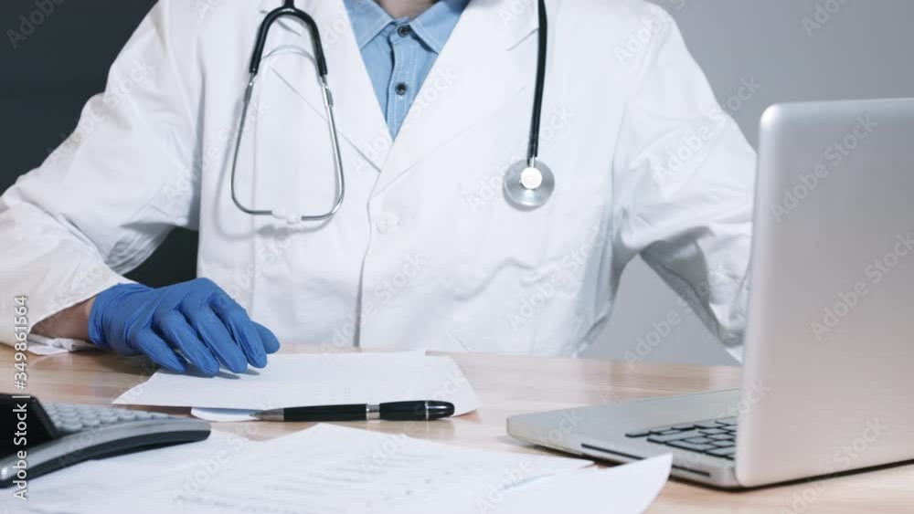 Hand of a doctor holding a vial of blood sample and writing at files. Hand of a doctor holding a vial of blood sample and writing at files.