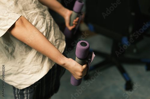 Unrecognized woman workout at home with Dumbbells medium closeup shot