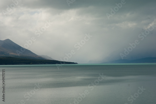 Dramatic cloud and sky over the misty lake and mountains, raining