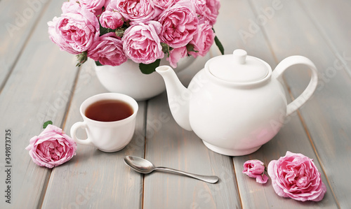 Tea with pink roses on grey wooden table, copy spase. Greeting card for mother's day. Valentine card.Valentine Romantic Breakfast February 14. Women's Day.Happy Birthday! Wedding invitation