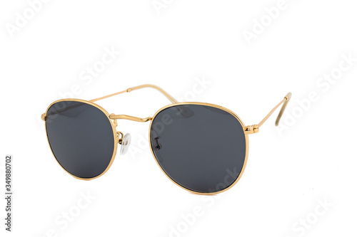 Sunglasses with oval gold wrap around frames and black lenses, isolated on white background, side view.