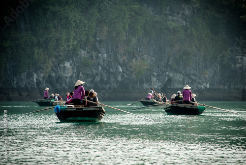 Halong bay, boats with passengers and boatmen rowing