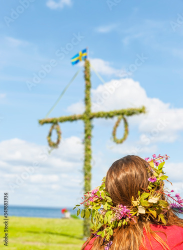 Mit Blumenkranz am Mittsommerbaum in Schweden
