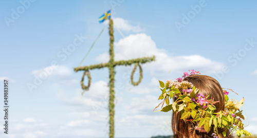 Mit Blumenkranz am Mittsommerbaum in Schweden