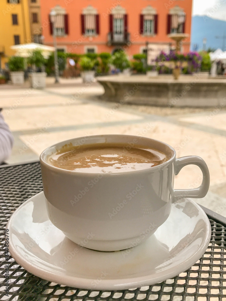 Cup of hot coffee on an outdoor table at a cafe.