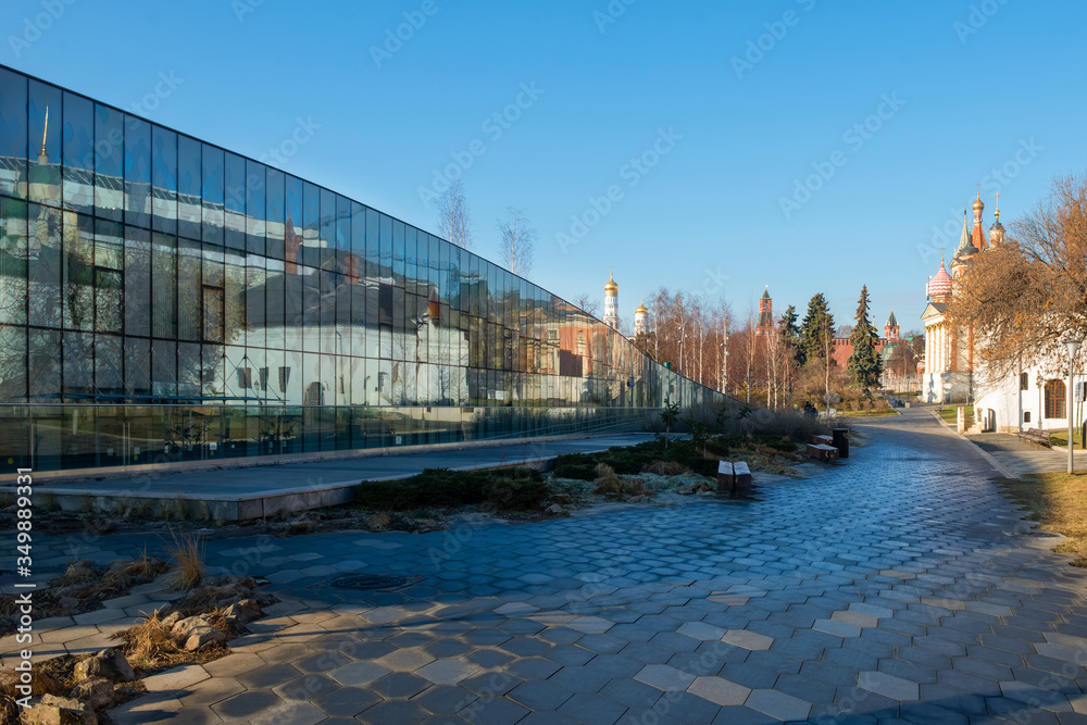 Fototapeta premium The Zaryadye Park. Varvarka Street. The Varvarinskaya Church, the old English courtyard and the Moscow Kremlin reflected in a glass facade of the house 6, Building 1