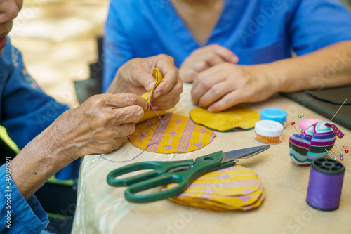 Obraz na płótnie Elderly woman with caregiver in the needle crafts occupational therapy  for Alzh