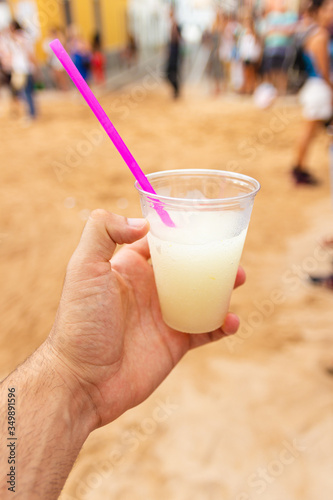 hand holds drink called pomada typical de menorca. With gin and lemonade (balearic islands, spain)