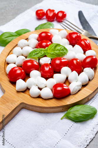 Italian food, fresh fresh green basil, white mini mozzarella cheese and red cherry tomatoes
