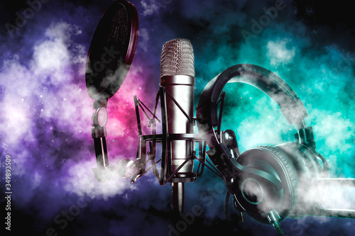 Condenser microphone and headphones closeup. Live sound light overlay smoke over