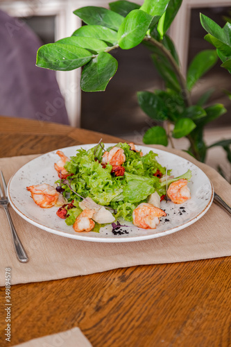 light healthy salad of fresh vegetables and shrimp. Photo in the interior
