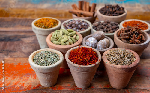 Indian spices collection  dried colorful condiment  nuts  pods and seeds and another spices in clay bowls