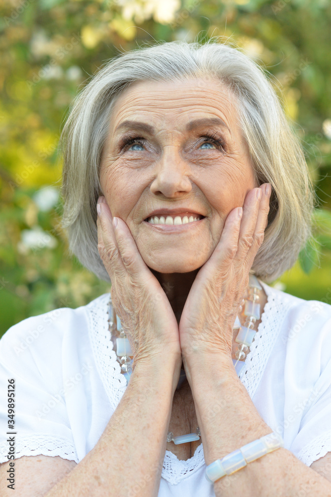 Portrait of senior smilling beautiful woman posing in spring park Portrait of senior smilling beautiful woman posing in spring park