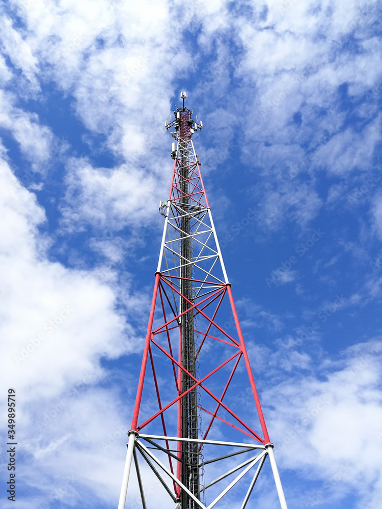 GSM repeater tower in front of blue cloudy sky GSM repeater tower in front of blue cloudy sky