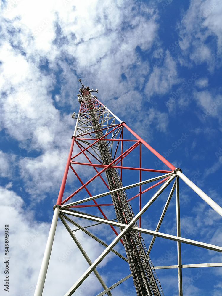GSM repeater tower in front of blue cloudy sky GSM repeater tower in front of blue cloudy sky