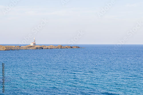 Seascape with a lighthouse in the background. Minorca. (balearic islands, spain)