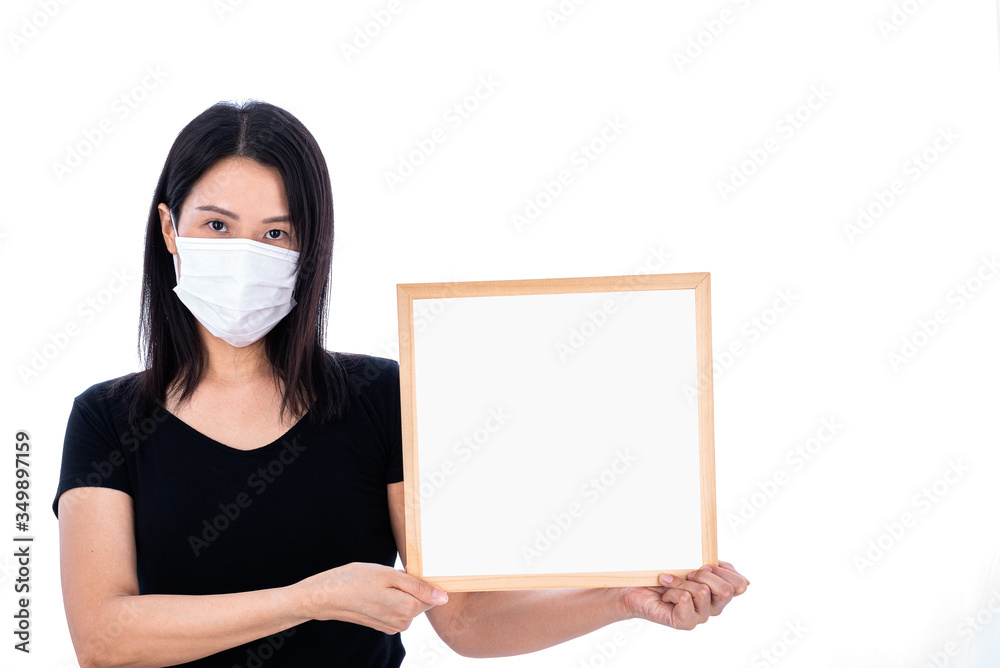 An Asian woman wearing a white mask and holding an empty board for writing COVID-19 prevention isolated on white background. An Asian woman wearing a white mask and holding an empty board for writing COVID-19 prevention isolated on white background.