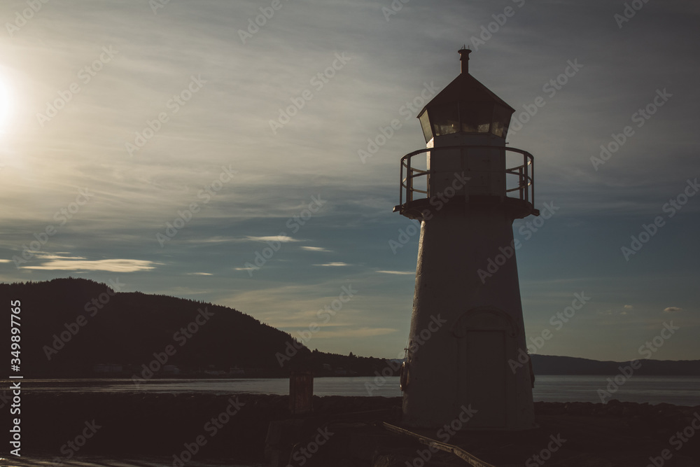 Lighthouse in silhouette at sunset and dramatic sky. Place for text or advertising