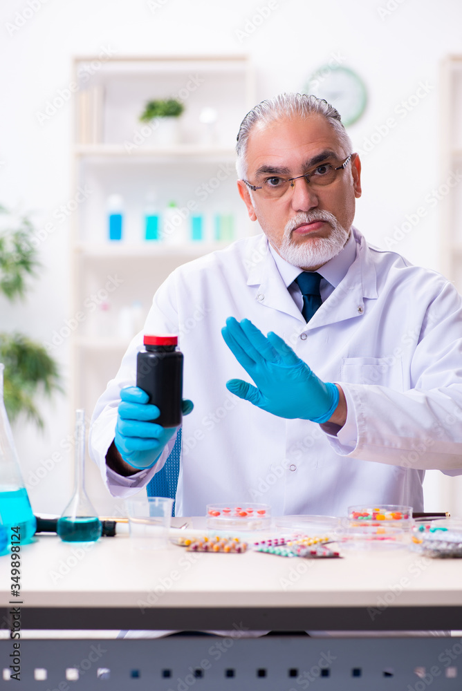 Fototapeta premium Old male chemist working in the lab