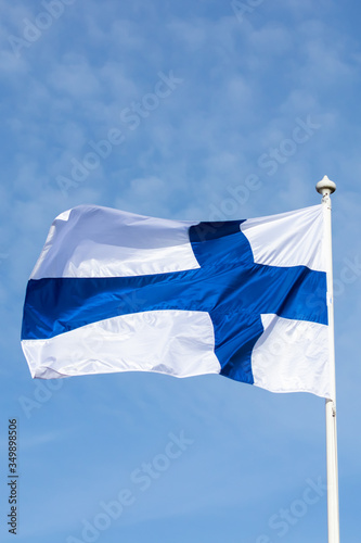 Fototapeta Finnish national flag on the wind against the blue sky