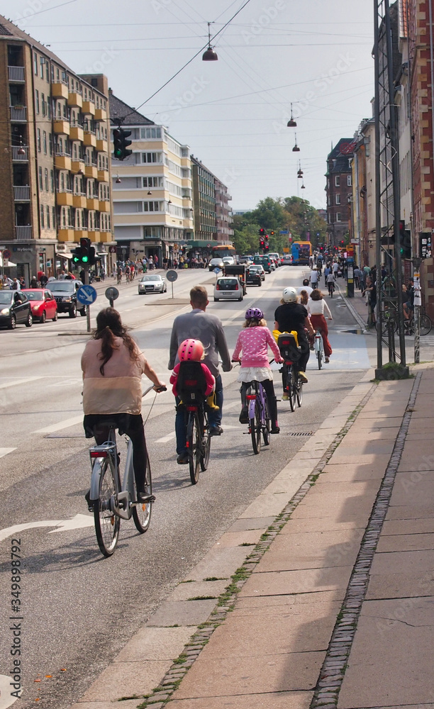 People riding bicycles lined up on the road.