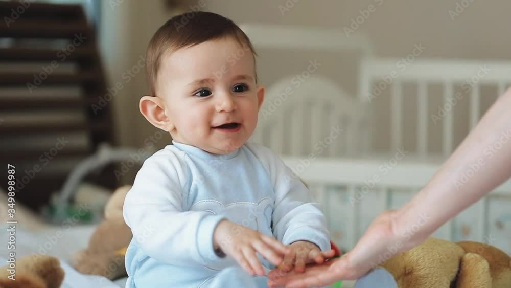 Close up of nice caucasian newborn baby on the bed and sucking a pacifier Close up of nice caucasian newborn baby on the bed and sucking a pacifier