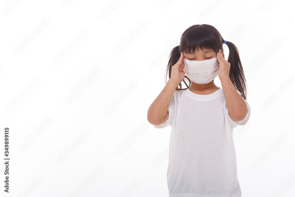 Asian child wearing a medical mask is feeling headache on white background. Asian child wearing a medical mask is feeling headache on white background.