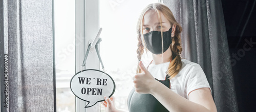 Coronavirus covid 19.Coffee shop woman owner with face mask, open after lockdown quarantine.End quarantine. Announcement we are open nv doors,  resumption shops, cafes,coffee houses, small businesses