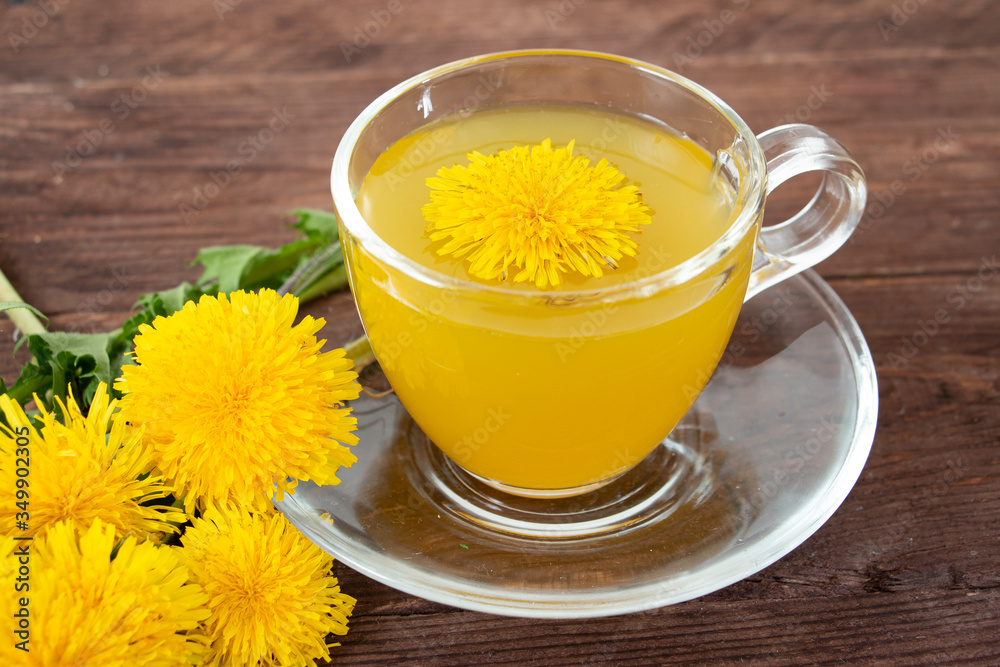 Glass cup with dandelion tea on a dark wooden table. Phytotherapy. Alternative medicine concept. Glass cup with dandelion tea on a dark wooden table. Phytotherapy. Alternative medicine concept.