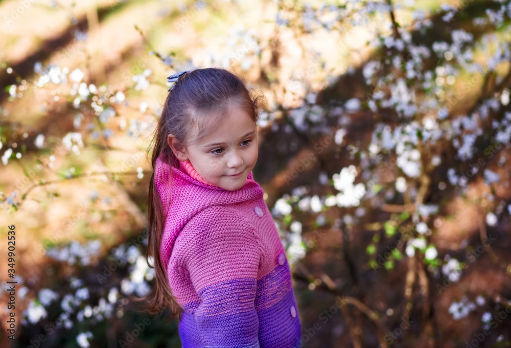 portrait of a little girl in a flowered garden
