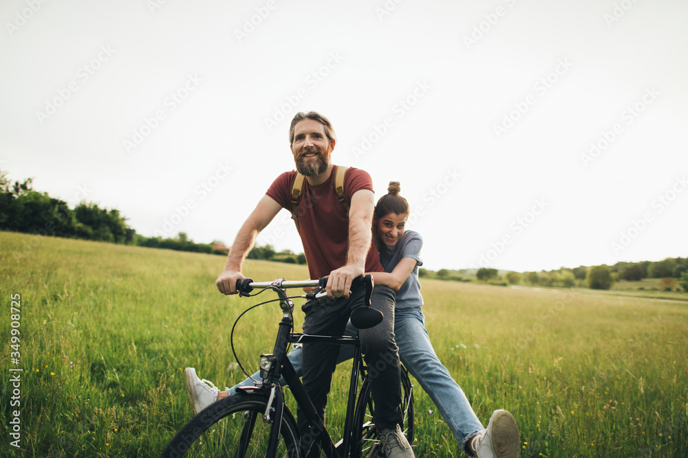 Romantic couple is riding a bike together in nature Romantic couple is riding a bike together in nature