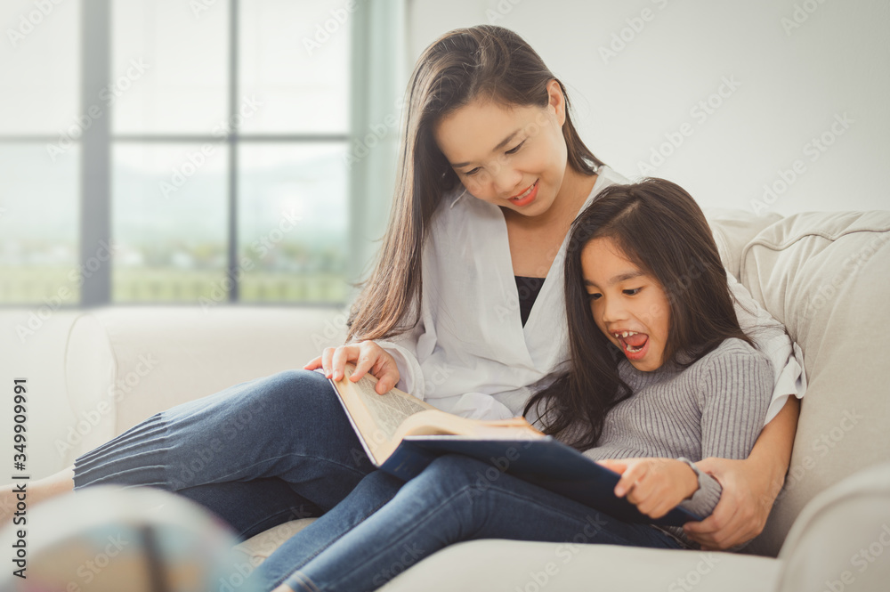 Mother and child home reading during Coronavirus or Covid-19 quarantine. Stay at home, Home education concept. Mother and child home reading during Coronavirus or Covid-19 quarantine. Stay at home, Home education concept.