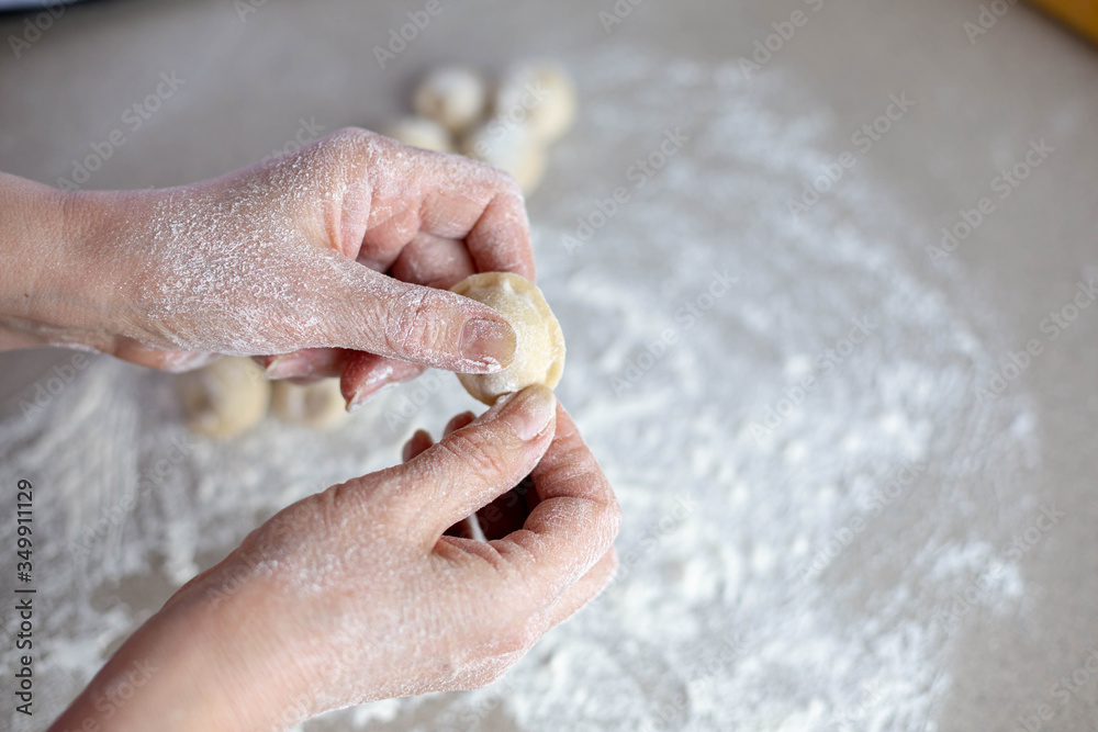 Woman sculpts homemade dumplings bear ears in the kitchen. Modeling dumplings closeup. Female hands sculpt dumplings. Woman sculpts homemade dumplings bear ears in the kitchen. Modeling dumplings closeup. Female hands sculpt dumplings.