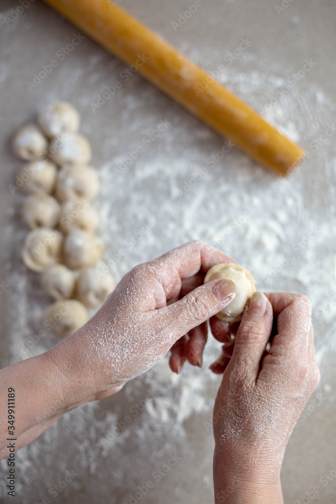 Woman sculpts homemade dumplings bear ears in the kitchen. Modeling dumplings closeup. Female hands sculpt dumplings. Woman sculpts homemade dumplings bear ears in the kitchen. Modeling dumplings closeup. Female hands sculpt dumplings.
