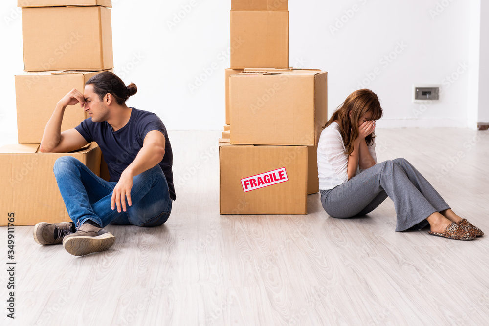 Young pair and many boxes in divorce settlement concept Young pair and many boxes in divorce settlement concept