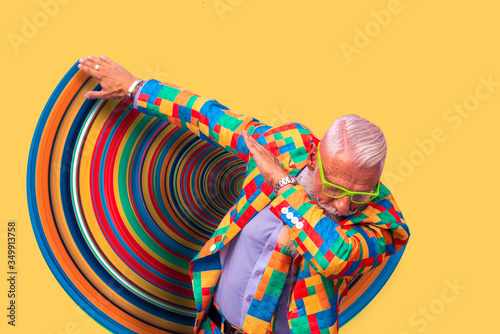 Old senior man performing dab dance moves. Concept about lifestyle and seniority. Isolated man on colored background and graphic effects photo