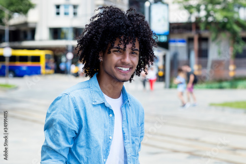 Mexican young adult man with long curly hair outdoor in city © Daniel Ernst