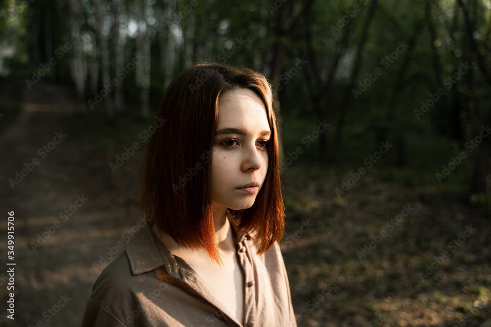 Naklejka premium portrait of a girl in the forest with brown hair
