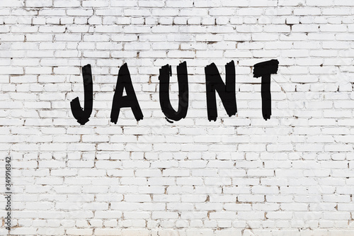 Word jaunt painted on white brick wall