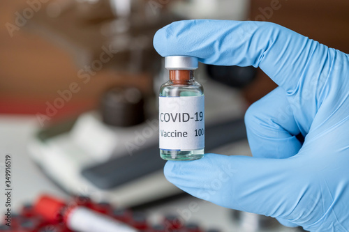 Hand holds Coronavirus Covid-19 Vaccine glass bottle. Healthcare And Medical concept.