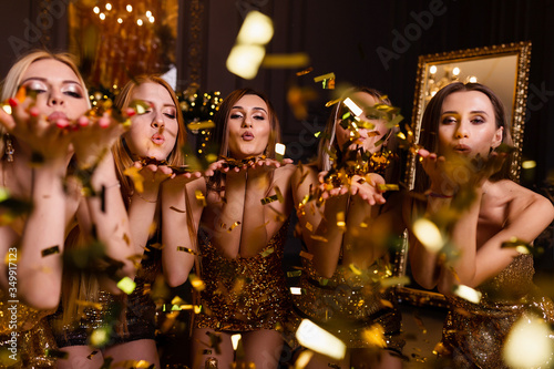 Fun party at girls, bachelorette party. New Year's party in the studio, dark background and gold decoration