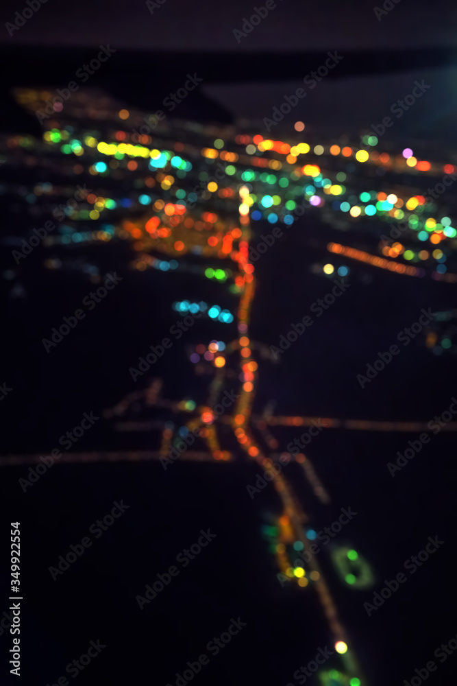Dark background view of city with lights from aeroplane. Night lights in the city.