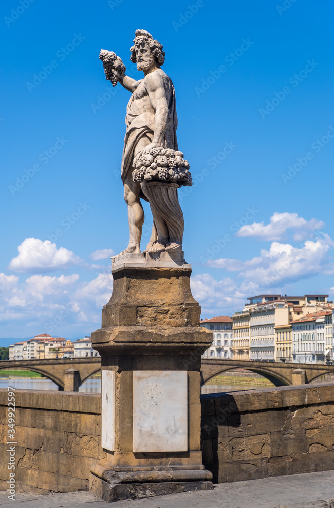 Statue of Autumn or Bacchus on Holy Trinity Bridge of Florence, Italy