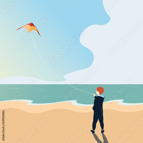 Boy holds a kite on the background of the sea.