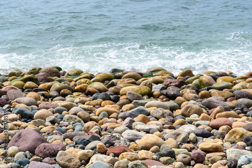 Fototapeta Naklejka Na Ścianę i Meble -  A sea wave rolls onto the coastal boulders. Background. Abstract.