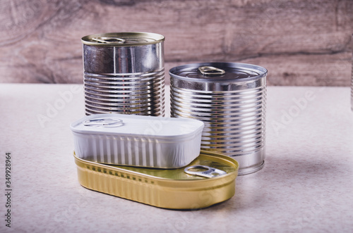 Set of various canned foods in tin cans on kitchen table, non-perishable, long shelf life food for survival in emergency conditions concept