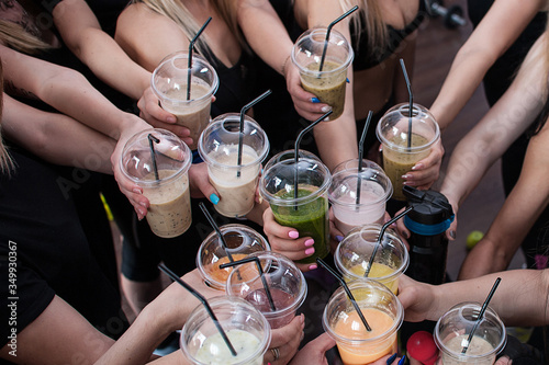 Fitness girl drinking a smoothie smoothies after a workout. Girls holding vegetable smoothies after a running sports fitness workout. Healthy clean eating lifestyle concept.