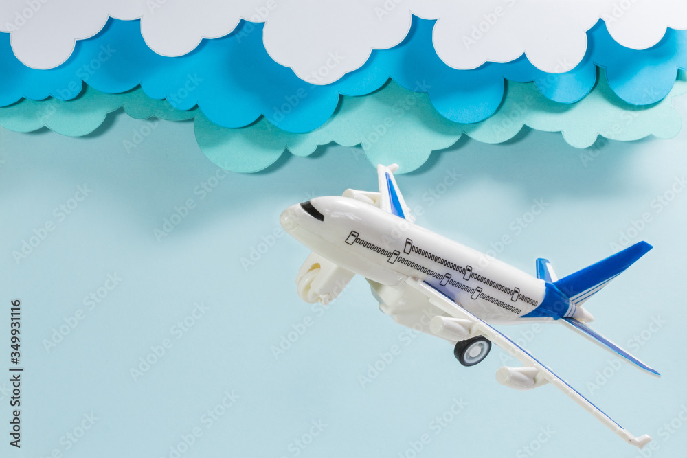 Fototapeta premium Plastic airplane, with cloudy sky made of paper
