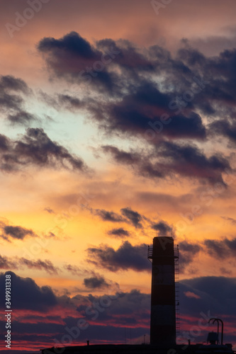 Portrait about a power station chimney silhouette in the sunset over Budapest after a heavy storm