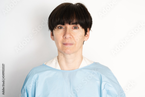 Middle-aged doctor putting on a protective gown © javiindy